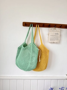 Detailed close-up of woven hollow mesh bags in mint green and mustard yellow colors