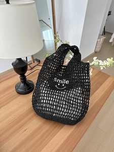 Detail of hand-woven black hollow tote bag with Smile embroidery and inner lining