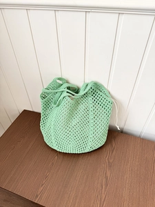 Detail of light green hollow cotton mesh bag with drawstring inner pouch for summer style