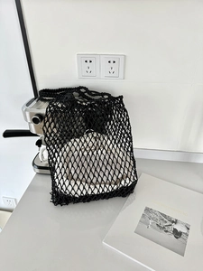 Detail der schwarzen Netztasche mit weißem Kordelzug-Futter für den Sommerurlaub am Strand