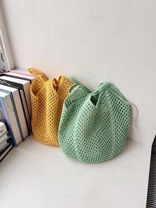 Detail view of woven hollow cotton shoulder bags in yellow and green with drawstring closure
