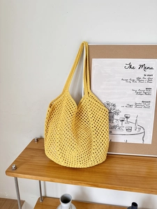Detail of hand-woven cotton rope tote bag in bright yellow with hollow mesh structure