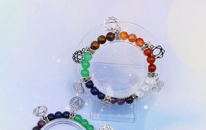 Detailed macro of 7 chakra natural stone bracelet with hollow silver yoga pendants