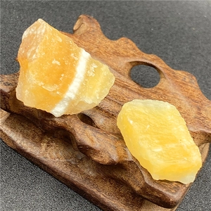 Gros plan de pierres brutes de calcite jaune naturelle sur un support en bois sombre