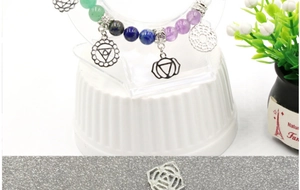 Close-up of 7 chakra natural stone bracelet with intricate silver hollow pendants