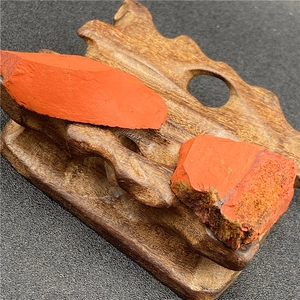 Vue rapprochée de deux pierres d'agate rouge brut sur un support en bois foncé