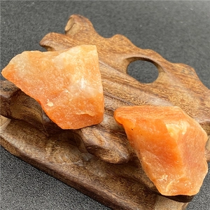 Pierres de cristal brut de calcite orange naturelle sur un support en bois sculpté
