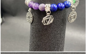 Macro shot of Chakra beaded bracelet with colorful natural stones and silver charms