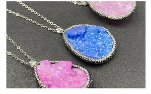 Gros plan de pendentifs en druse de cristal avec bords en strass en rose et bleu