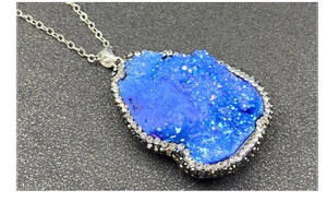 Gros plan d'un pendentif druzy bleu bohème avec bordure en strass scintillants