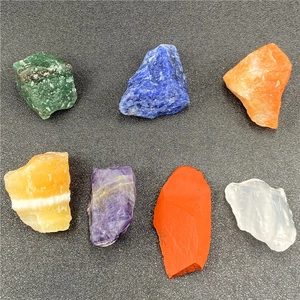 Vue à plat de sept cristaux de chakra naturels bruts incluant améthyste et quartz
