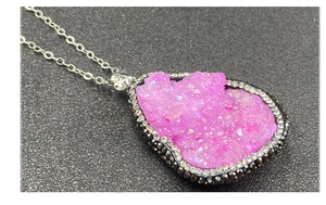 Vue détaillée du pendentif druzy rose en forme de larme avec strass sur chaîne argentée