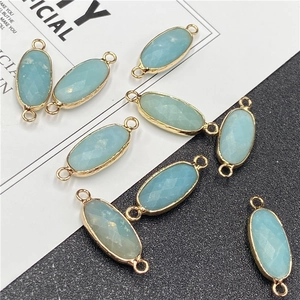 Détail de breloques en cristal bleu clair facetté avec bords dorés et doubles anneaux