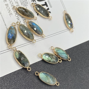 Vue détaillée de connecteurs ovales en labradorite facettée avec éclat bleu et bordure dorée