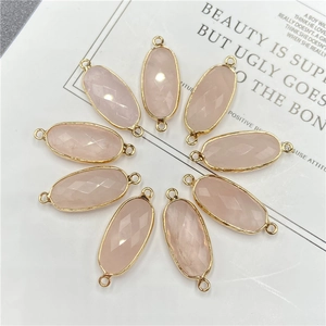 Détail de breloques ovales en cristal rose facetté avec doubles boucles dorées