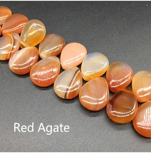 Macro shot of polished teardrop red agate beads with natural striped textures