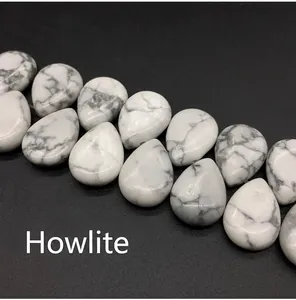 Macro shot of teardrop-shaped white howlite stone beads with grey marble veins for jewelry diy