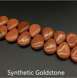 Macro view of teardrop-shaped red goldstone beads with shimmering metallic inclusions