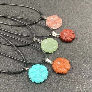 Detailed view of five colorful flower-shaped stone pendants with black cord necklaces