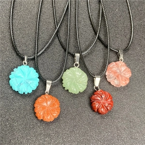 Detail of five carved agate and crystal flower pendants on black braided cords