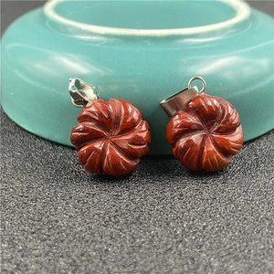 Close-up of red agate flower pendants with intricate carvings and silver metal clasps