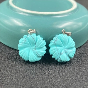 Detailed close-up of turquoise flower pendants with natural black mineral veins and silver clasps