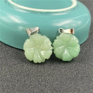 Detailed macro of two light green stone flower pendants with spiral carved patterns
