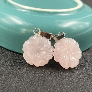 Macro detail of hand-carved pink rose quartz flower pendants with silver bails