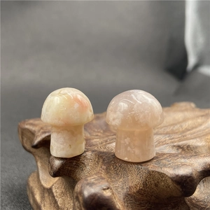 Close-up of agate mushroom figurines with natural pink quartz textures on wood base