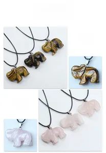 Gros plan des pendentifs éléphants en œil de tigre et quartz rose sculptés