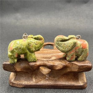 Détail de pendentifs éléphant en unakite sculptés à la main avec motifs naturels vert et rose