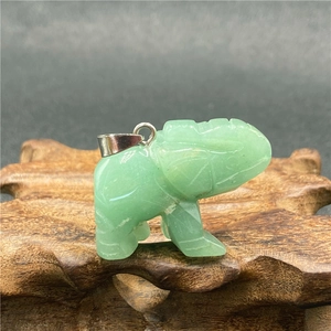 Vue détaillée du pendentif éléphant en aventurine sculpté avec bélière argentée sur bois