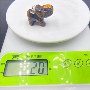 Pendentif éléphant en œil de tigre de 20g posé sur une balance numérique de précision
