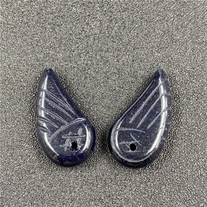 Macro view of blue sandstone angel wing charms with sparkling texture for DIY jewelry