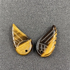 Macro detail of tiger eye stone angel wing pendants with natural golden texture