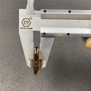 Detail view of 8.5mm thick carved amber brown wing pendant measured with a caliper
