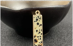 Detail eines rechteckigen Dalmatiner-Jaspis-Anhängers mit vergoldetem Rand und Ring