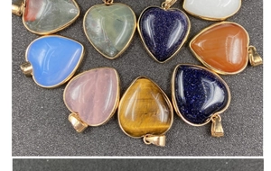 Dettaglio di ciondoli in pietra a forma di cuore con bordi dorati in vari colori