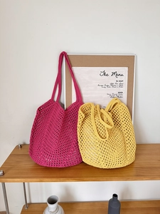 Detail of yellow and fuchsia hollow mesh crochet tote bags showing handmade knit texture