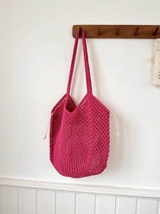 Close-up of deep pink hollow crochet cotton rope tote bag with drawstring closure detail