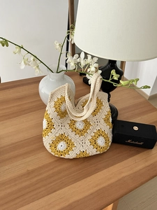 Dettaglio della borsa tote in crochet fatta a mano con motivi a girasole su scrivania