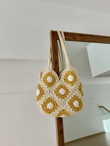 Dettaglio borsa tote a uncinetto fatta a mano con girasoli su cornice in legno