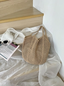 Close-up of beige hollow knit cotton rope tote bag with mesh crochet texture