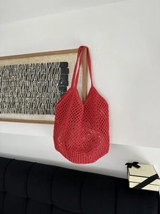 Detail of red hollowed-out cotton woven shoulder bag with large capacity mesh design