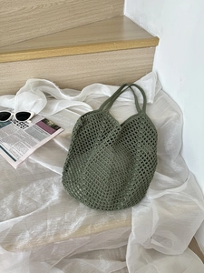 Detailed view of the dark green hollow woven tote bag texture and reinforced cotton handles