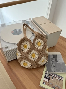Macro scatto della borsa tote all'uncinetto con margherite 3D su filato di cotone marrone