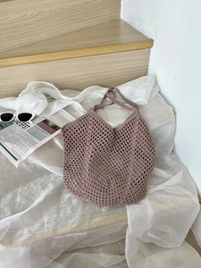 Detail of hollow mesh crochet tote bag in dusty pink with woven cotton rope texture