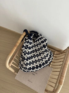 Detailed close-up of navy and white hand-woven tote bag with hollow geometric star pattern
