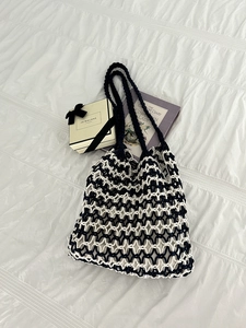 Detail of handmade woven beach bag showing black diamond mesh over white cotton cord