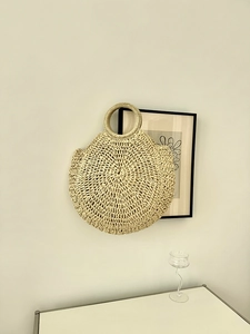 Dettaglio della trama a spirale di una borsa a mano tonda in paglia per le vacanze